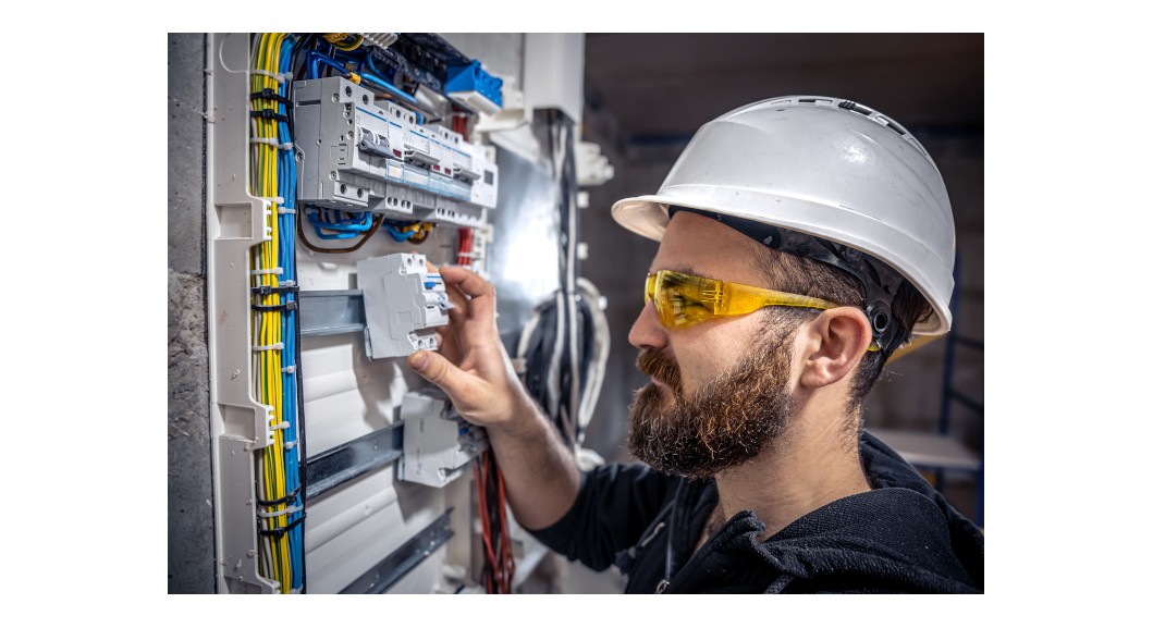 An electrician fixes a switchboard